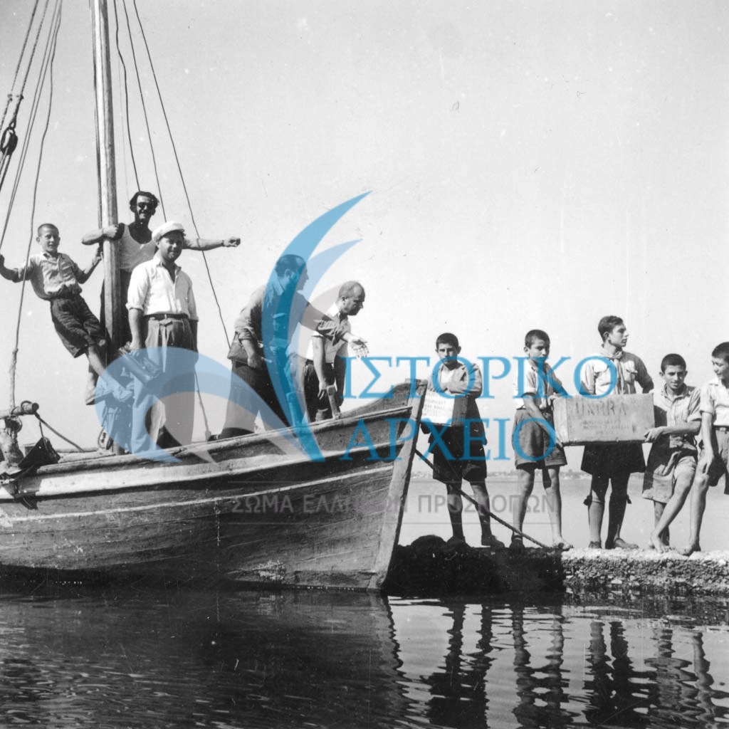 Πρόσκοποι ξεφορτώνουν από πλοιάριο ανθρωπιστική βοήθεια της UNRA το 1949.