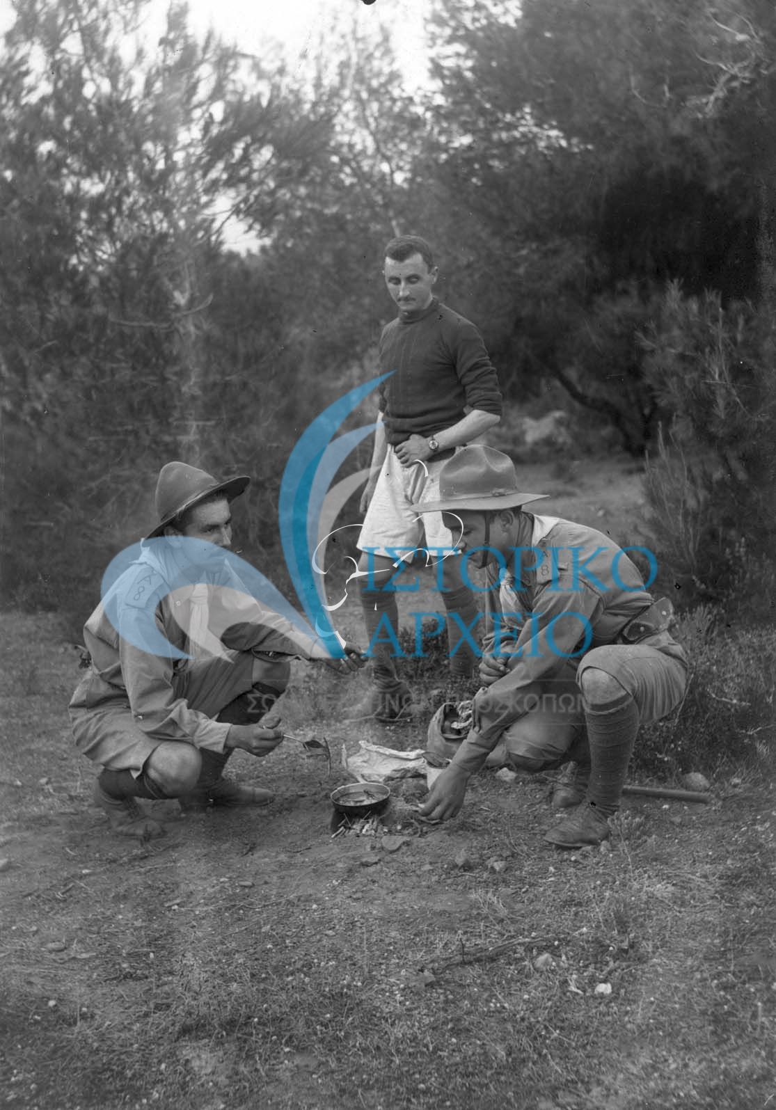 Οι πρώτοι πρόσκοποι της Αθήνας προετοιμάζουν το φαγητό σε εκδρομή Συστήματος στην περιοχή της Χελιδονούς το 1914 (σημερινή Νέα Κηφισιά).