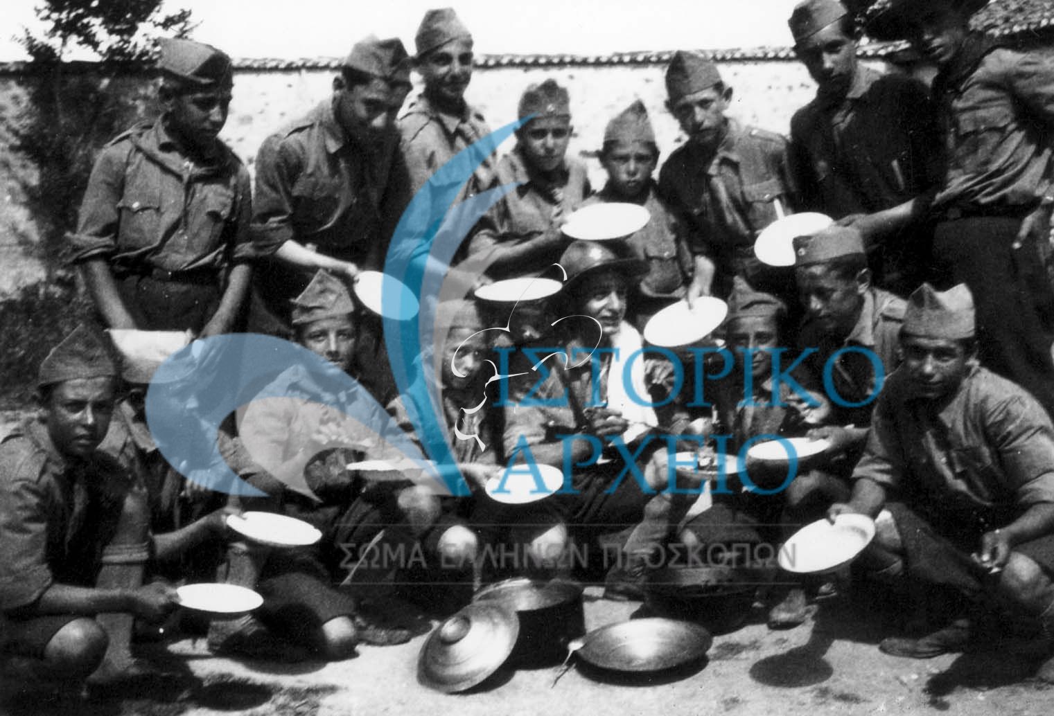 Πρόσκοποι της Ξάνθης σε εκδρομή στη περιοχή Χιονίστρα τον Ιούλιου του 1933 αναμένοντας να γεμίσουν με μεσημεριανό φαγητό τα σκεύη τους.