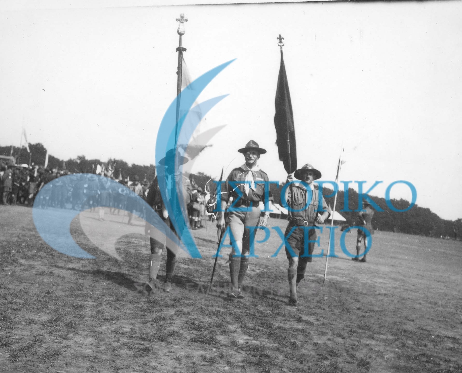 Ο Γενικός Έφορος Αντώνης Μπενάκης, με τον Αρχηγό της ελληνικής προσκοπικής Αποστολής Σπ.Βλάχο στο Τζάμπορη της Αγγλίας το 1929 με την ΕλληνικήΣημαία και την αναμνηστική σημαία του Τζάμπορη.