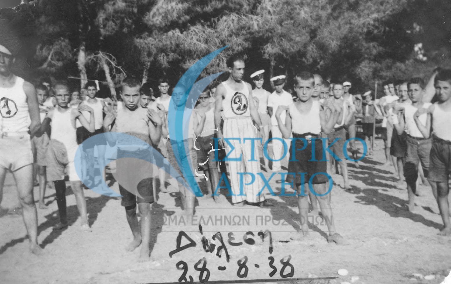 Πρωινή γυμναστική στην Κατασκήνωση .Πρόσκοποι της  Νίκαιας- Κοκκινιά του   Πειραιά σε κατασκήνωση στο Δήλεση το 1938  1. Θεολογίτης 2. Βουζάτος