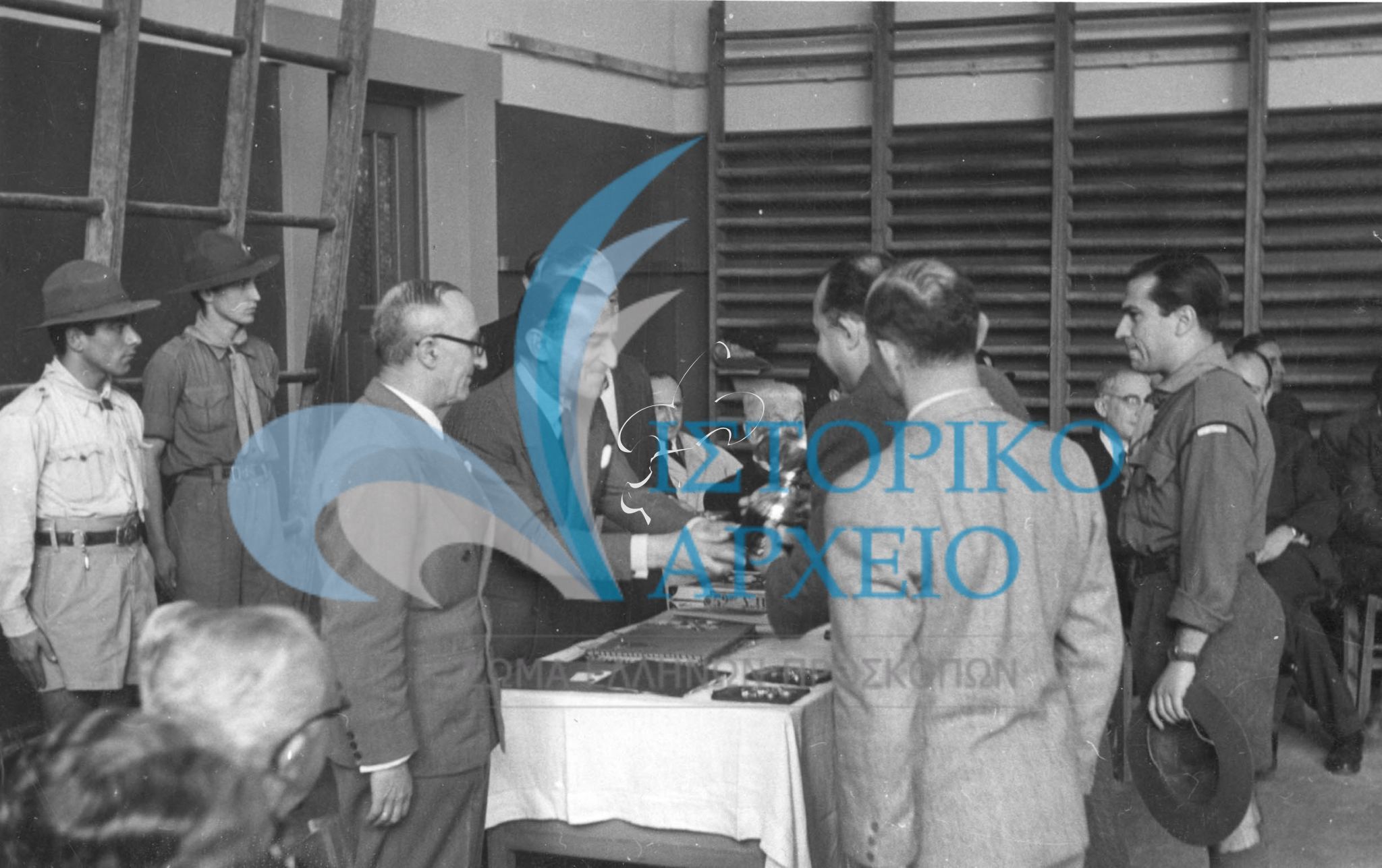 Ο πρόεδρος του Τοπικού Προσκοπικού Συνδέσμου Αθηνών απονέμει έπαθλα σε νικητές του Μεγάλου Παιχνιδιού πόλης το 1948. Μαζί του ο έφορος Η. Ησαϊας.