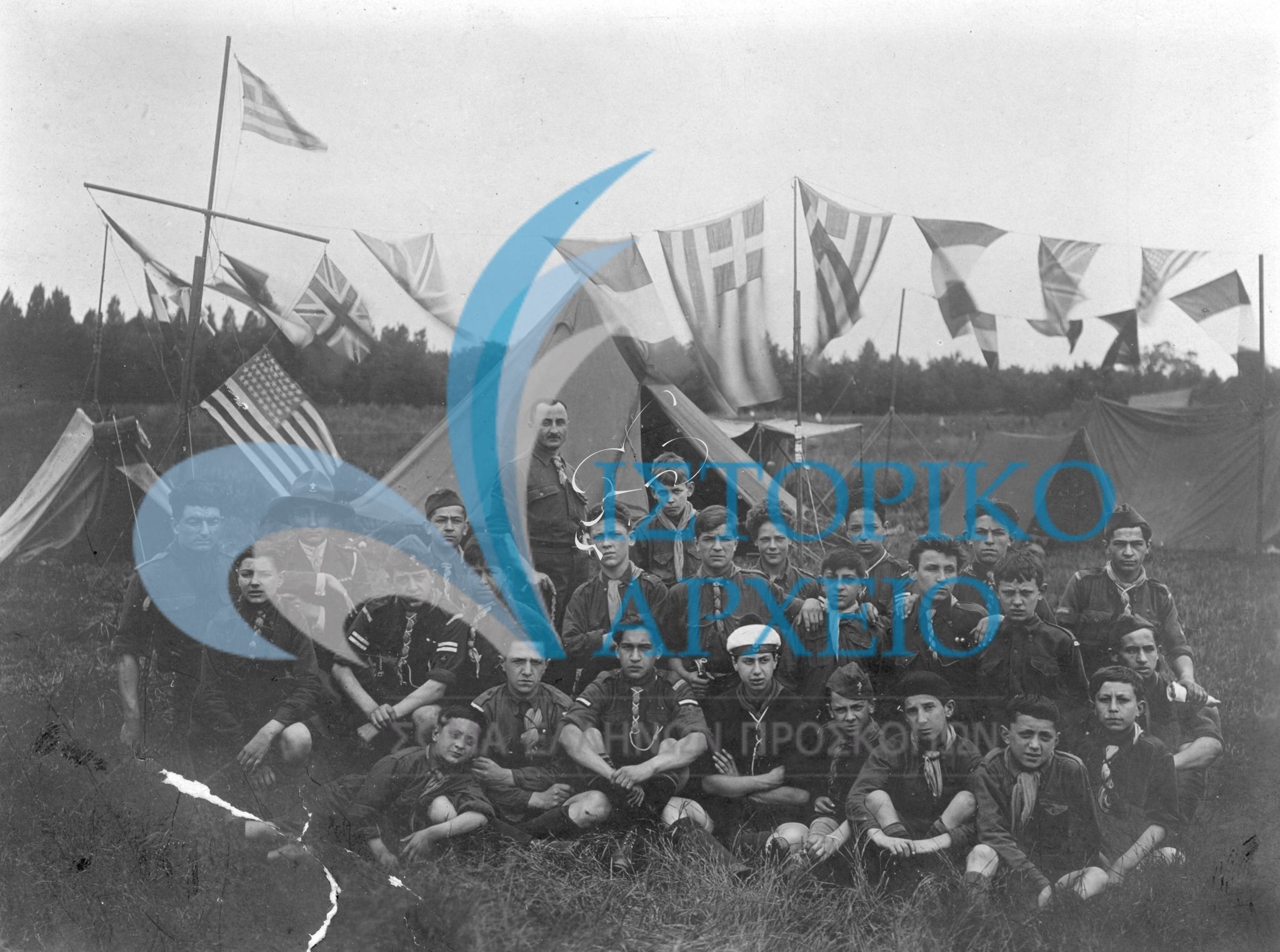 Η 1η ελληνική ομάδα Παρισίων με τον ιδρυτή της Ησαϊα Ησαϊα συμμετέχει σε προσκοπική γιορτή στο Meudon στη θέση Patte d' Oie τον Ιούλιου του 1923. Mε το βέλος έχει σημαιωθεί ο μετέπειτα αρχηγός της ομάδας Αν. Ωρολογόπουλος.