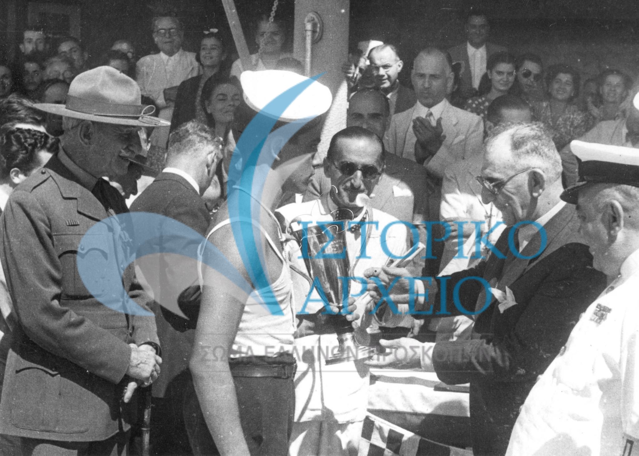 Ο Υπουργός Εμπορικής Ναυτιλίας Βουλγαρίδης απονέμει έπαθλο σε ομάδα που νίκησε στους Ναυτοπροσκοπικούς Αγώνες Αθηνών το 1948 στο Π. Φάληρο.