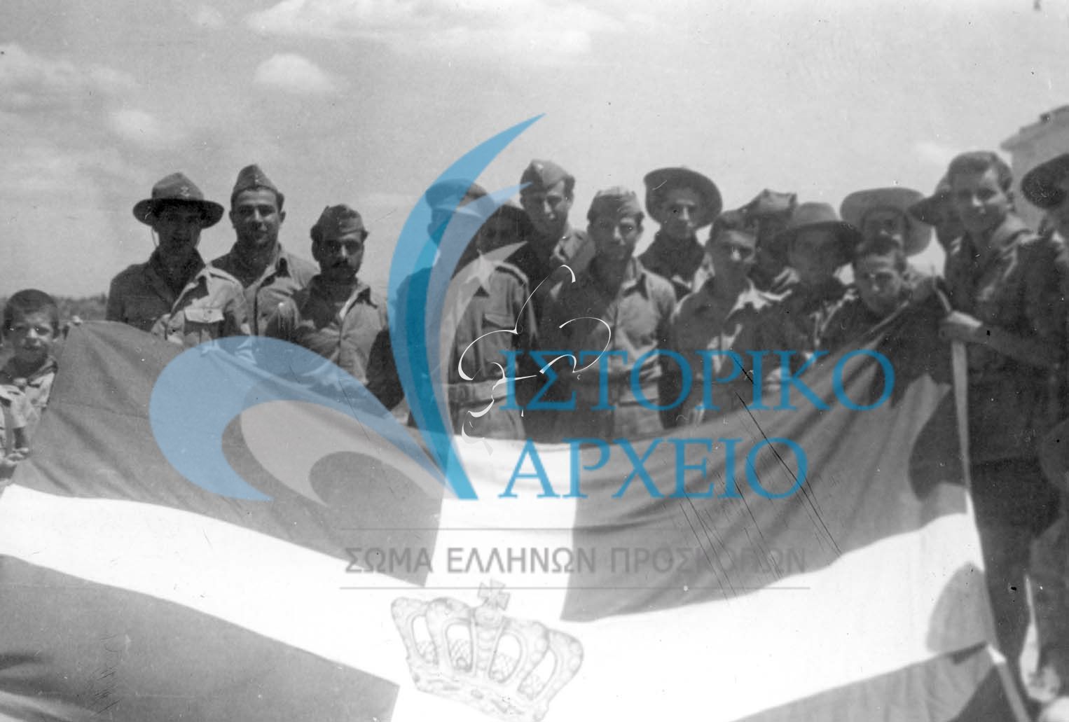 Κατά την διάρκεια επίσκεψης στο μεθοριακό φυλάκιο της Νίκης την περίοδο του εμφυλίου, πρόσκοποι δωρίζουν ελληνική σημαία στο διμοιρίτη της στρατιωτικής δύναμης.