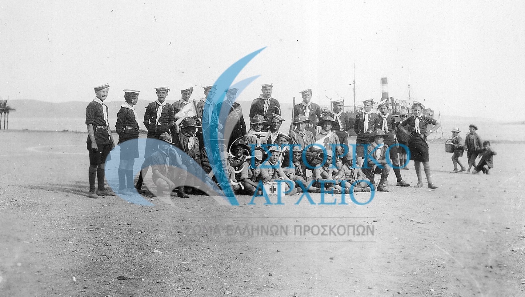 Πρόσκοποι της 3ης Ομάδας Αθηνών με τα πρώτα λυκόπουλα σε διέλευση από το Λαύριο για τη κατασκήνωση στο κτήμα Ζαχαρίτσα του Σουνίου το 1931.