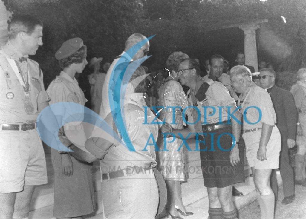 Τα επιτελείο των Εθνικών Αποστολών που συμμετείχαν στο 11ο Παγκόσμιο Τζάμπορη Μαραθώνα το 1963 σε δεξίωση από στα Ανάκτορα της Αθήνας. Στη φωτογραφία ο Βασιλιάς Παύλος με την Βασίλισσα Φρειδερίκη ο Διάδοχος Κωνσταντίνος με στολή προσκόπου και η Πριγκίπισσα Ειρήνη με στολή οδηγού.