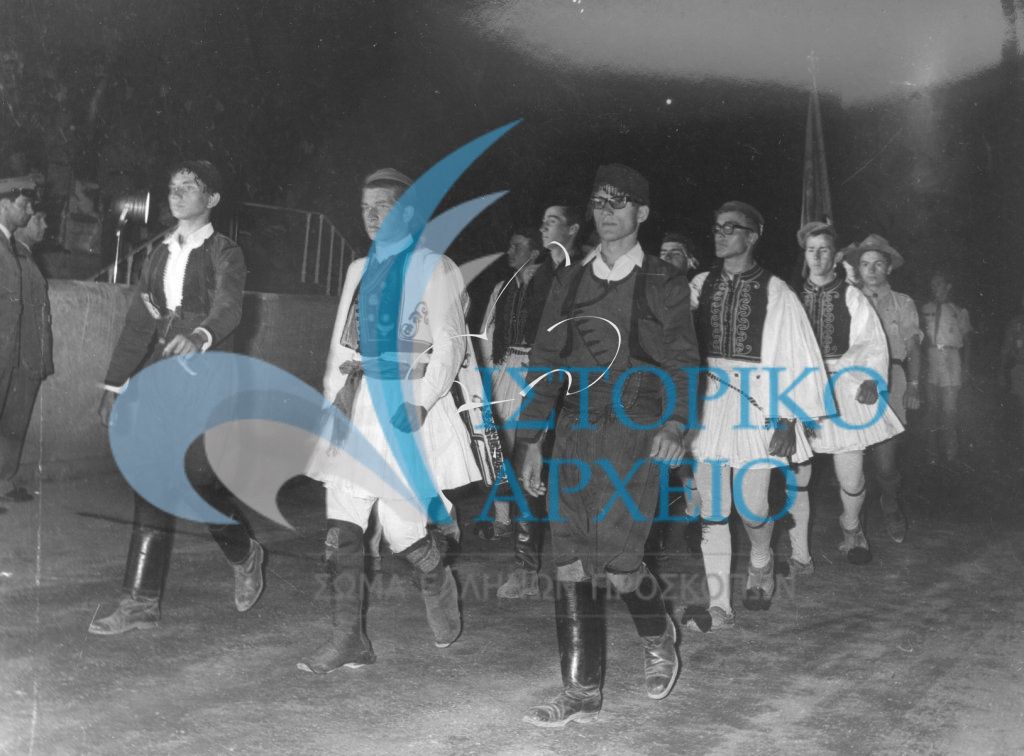 Έλληνες πρόσκοποι που συμμετείχαν στο 11ο Παγκόσμιο Τζάμπορη του Μαραθώνα φορώντας εθνικές ενδυμασίες εισέρχονται στην Διεθνή Προσκοπική Επίδειξη στο Παναθηναϊκό Στάδιο τον Αύγουστο του 1963.
