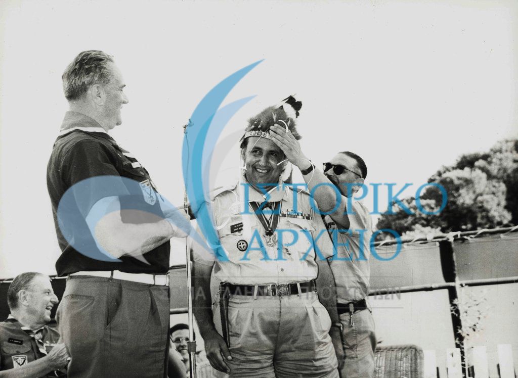 Οι πρόσκοποι των ΗΠΑ στο 11ο Τζάμπορη Μαραθώνα το 1963 προσφέρουν στον Γ. Έφορο Δ. Αλεξάτο τα Φτερά του Ινδιάνου Αρχηγού ως ένδειξης προσκοπικής φιλιάς.