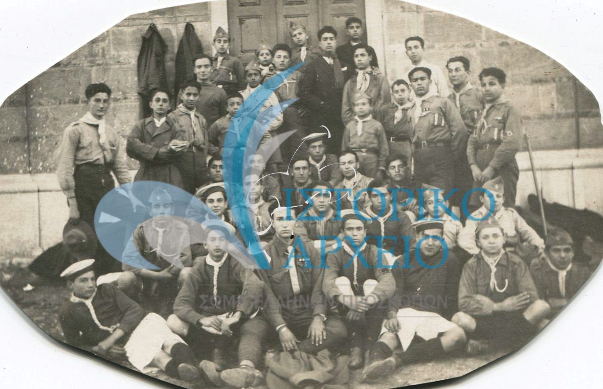 Η 1η Ομάδα Πατρών σε εκδρομή στο Αίγιο τη πρωτοχρονία του 1928. Αναμνηστική φωτογραφία έξω από τον Μητροπολιτικό Νάο Παναγίας Φανερωμένης Αιγίου. 
