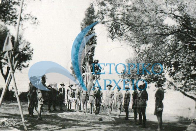 Το 6ο Σύστημα Αθηνών στην κατασκήνωση στην Λίμνη Ευβοίας στον Αγιο Ιωάννη το 1938. Η ομάδα σε κύκλο μπροστά από το εκκλησάκι. Αρχηγός ο Γ. Κωνσνταντίνου