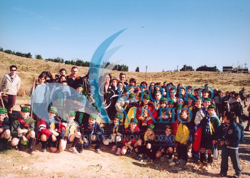 Πρόσκοποι και Λυκόπουλα με την Υπουργό Περιβάλλοντος Χωροταξίας και Δημοσίων Έργων Β. Παπανδρέου κατά την δεντροφύτευση για την Ημέρα Δάσους το 2003.