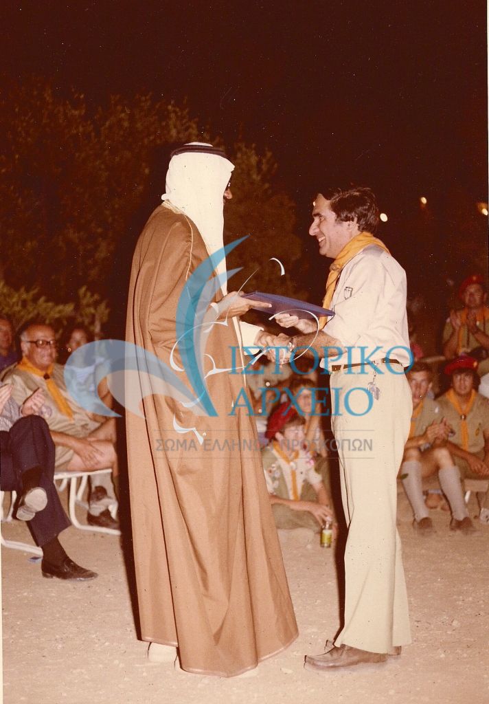 Ο ΓΕ Ν. Καλογεράς λαμβάνει αναμνηστικό κατά την κοινή κατασκήνωση Ελλήνων - Αμερικάνων και  Σαουδάραβων Προσκόπων (Camporee) στο Σούνιο το 1981.
