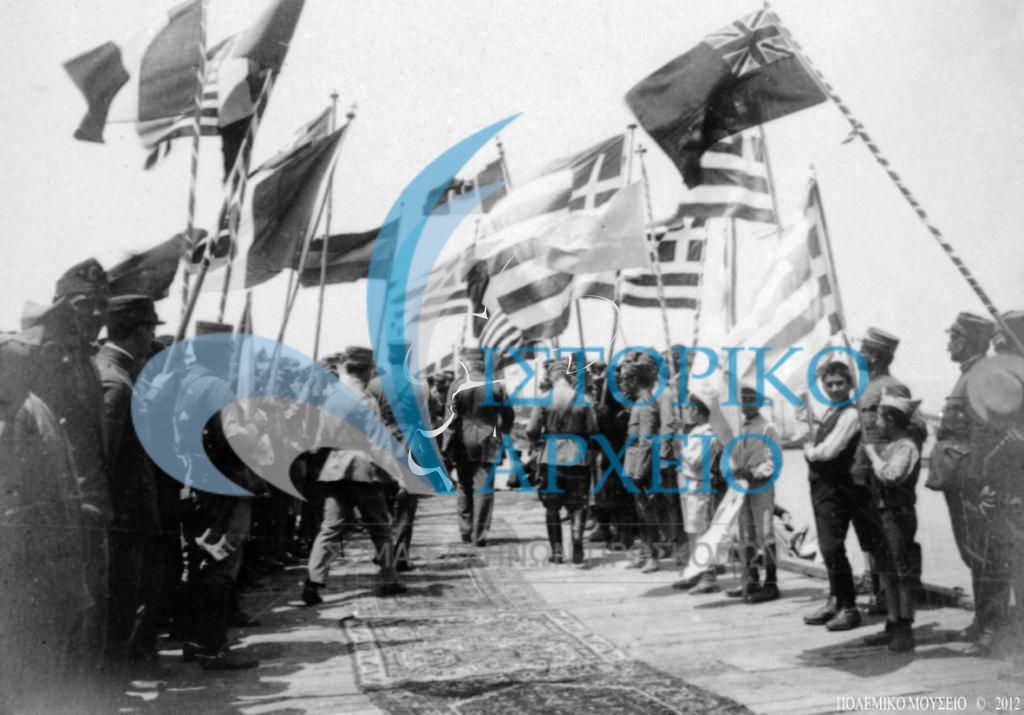 Πρόσκοποι, μαθητές και εκπρόσώποι της τοπικής κοινωνίας με ελληνικές και συμμαχικές σημαίες στην υποδοχή του Βασιλιά Κωνσταντίνου στην Πάνορμο της Μικράς Ασίας κατά την διάρκεια της μικρασιατικής εκστρατείας.