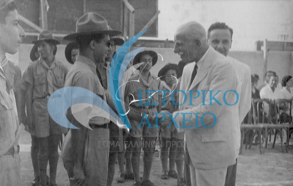 Ο Αντώνης Μπενάκης συνομιλεί με βαθμοφόρο της 3ης Ομάδας Αλεξάνδρειας κατά την επίσκεψή του το 1945.