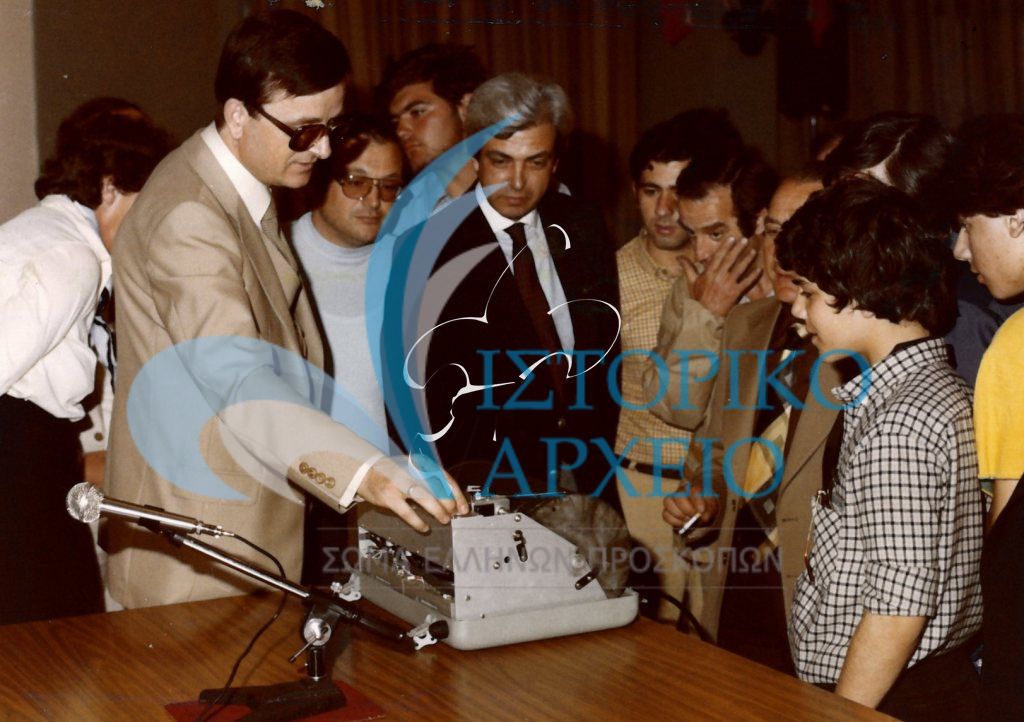 Ο καθηγητής του Γεωδυναμικού Ινστιτούτου Δρ Αχ. Οικονομίδης επιδεικνύει τη λειτουργία φορητού σεισμογράφου στον Γενικό Έφορο Γ. Ασημακόπουλο και σε άλλα μέλη του ΣΕΠ κατά την διάρκεια ομιλίας για τους σεισμούς το 1981.
