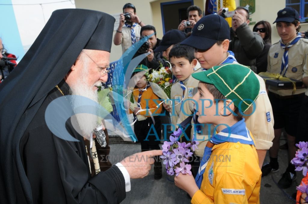 Λυκόπουλα και Πρόσκοποι υποδέχονται τον Οικουμενικό Πατριάρχη Βαρθολομαίο στα εγκαίνια του Προσκοπικού Κέντρου Περιβαλλοντικής Εκπαίδευσης Ασώματου Λέσβου το 2009.