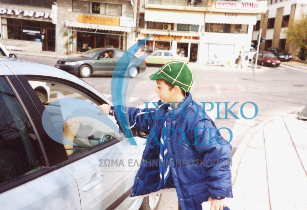 Λυκόπουλο προσφέρει ενημερωτικό υλικό για την προστασία του Περιβάλλοντος σε οδηγούς στην Καστοριά την Ημέρα Δάσους του 2002.