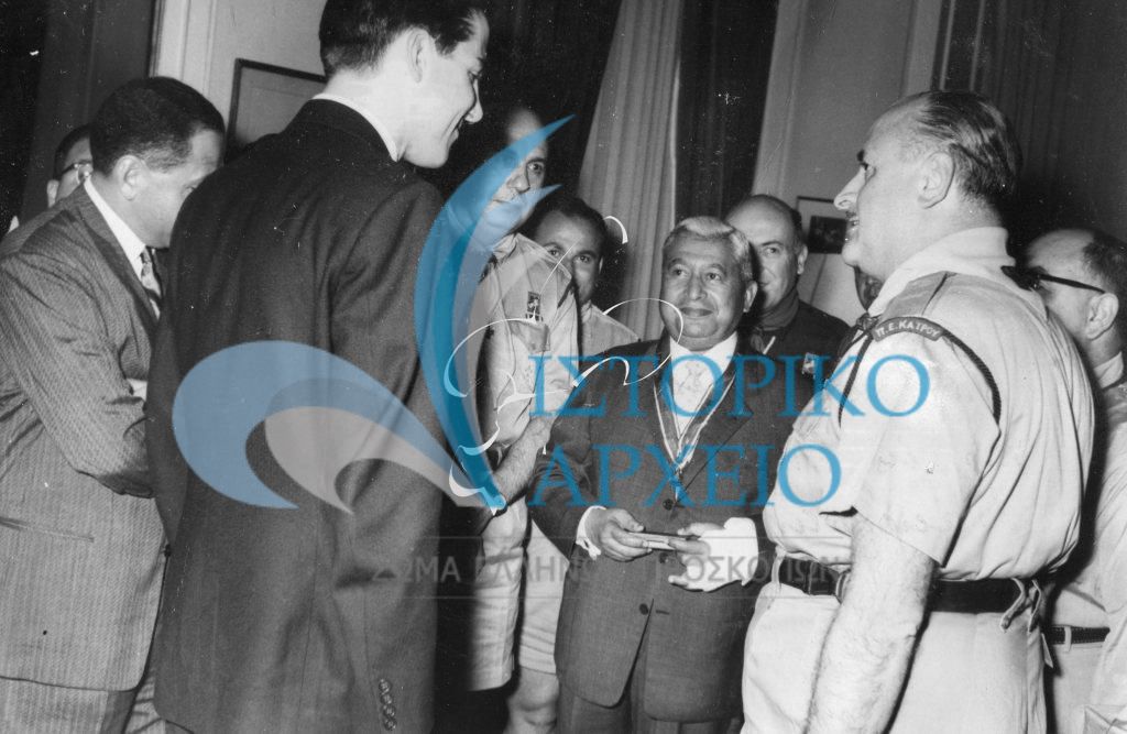 Ο Διάδοχος Κωνσταντίνος με τον έφορο διεθνών σχέσεων των αιγυπτίων προσκόπων, μετά την απονομή του μεταλλίου προσκοπικής αξίας τον Πρόεδρο των Αιγυπτίων Προσκόπων Χουσείν Όρμη το 1961. Διακρίνεται ο ΠΕ Καϊρου Ι. Λιούφης και στέλέχη των ελλήνων προσκόπων Αιγύπτου.