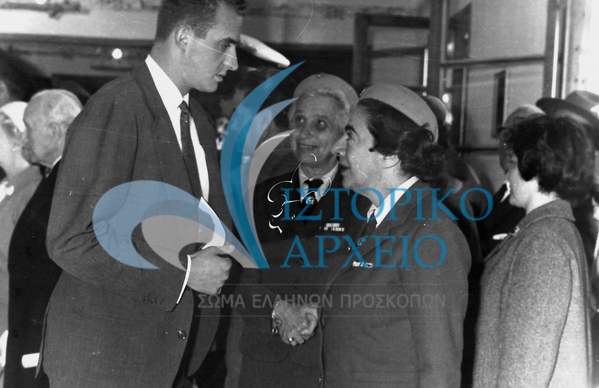 Η Γενική Έφορος του Σώματος Ελληνίδων Οδηγών με τον Πρίγκιπα των Αστουρίων Δον Χουάν Κάρλος στα εγκαίνια της Εστίας προσκόπων και οδηγών στη Νέα Σμύρνη τον Μάιο του 1962.