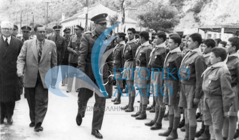 Ο Βασιλιάς Παύλος επιθεωρεί προσκόπους της Ομάδα της Τεχνικής Σχολής Βορειοδυτικής Μακεδονίας του Εθνικού Ιδρύματος στη Καστοριά το 1954. Συνοδεύεται από τον διευθυντή του Ιδρύματος και τον Νομάρχη Σταμούλα.