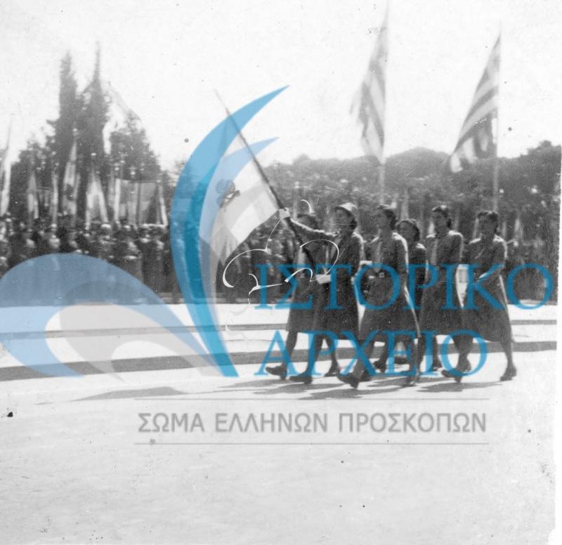 Η Σημαία του Σώματος Ελληνίδων Οδηγών σε παρέλαση για την 28η Οκτωβρίου του 1947 μπροστά από τον Άγνωστο Στρατιώτη στην Αθήνα.