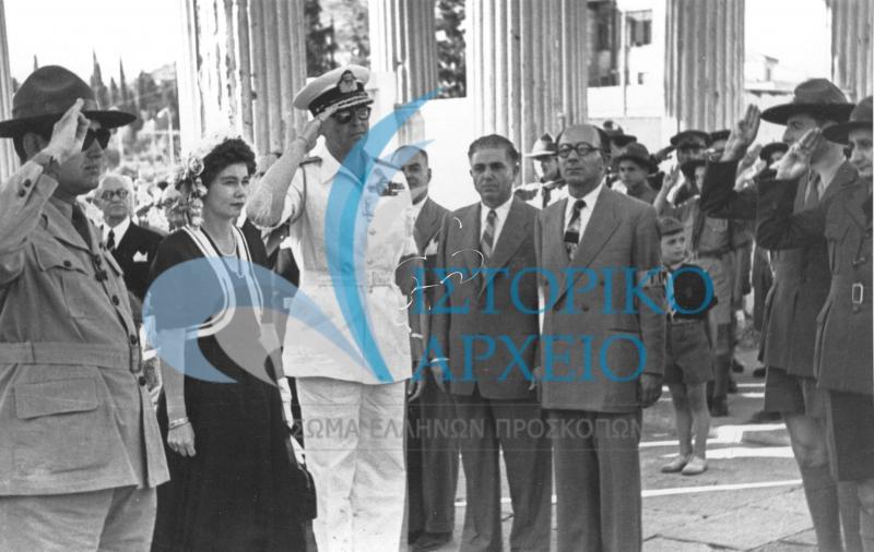 Ο Βασιλιάς Παύλος χαιρετίζει τα μέλη του Διοικητικού Συμβουλίου του ΣΕΠ και του Τοπικού Προσκοπικού Συνδέσμου Αθηνών εισερχόμενος στο Στάδιο για την προσκοπική επίδειξη το 1949. Το συνοδεύει με παραδοσιακή ενδυμασία η Βασίλισσα Φρειδερίκη.