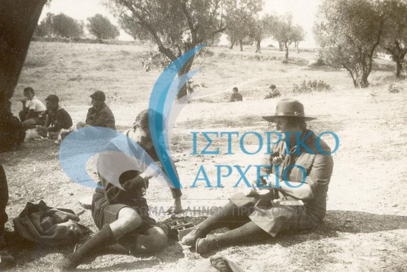Η Ακέλας της 3η Αγέλης Μενιδίου μαζί με τον Βαθμοφόρο της 9ης Αγέλης Αθηνών Δημήτριο Αλεξάτο στην διάρκεια του μεσημεριανού φαγητού εκδρομή στο Μενίδι το 1936.