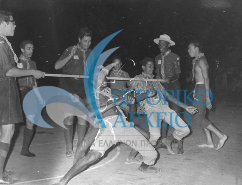 Αντιπροσωπεία πρόσκοπων από την Νιγηρία  που συμμετείχαν στο 11ο Παγκόσμιο Τζάμπορη του Μαραθώνα χορεύουν λίμπο στην Διεθνή Προσκοπική Επίδειξη στο Παναθηναϊκό Στάδιο τον Αύγουστο του 1963.