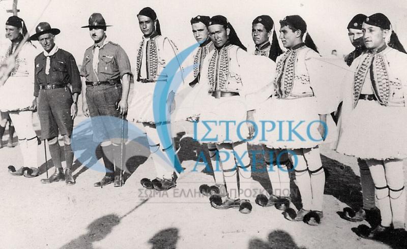 Η ελληνική προσκοπική αποστολή με ευζωνικές ενδυμασίες στην έναρξη του Τζάμπορη της Ουγγαρίας το 1933. Διακρίνονται από αριστερά: Α. Φάκαρος, Αθ. Λευκαδίτης, Ι. Σκαραμαγκάς, Α. Στεφανουδάκης, Τ. Γκαζιάνης, Αργυρίου, Μ. Λένος