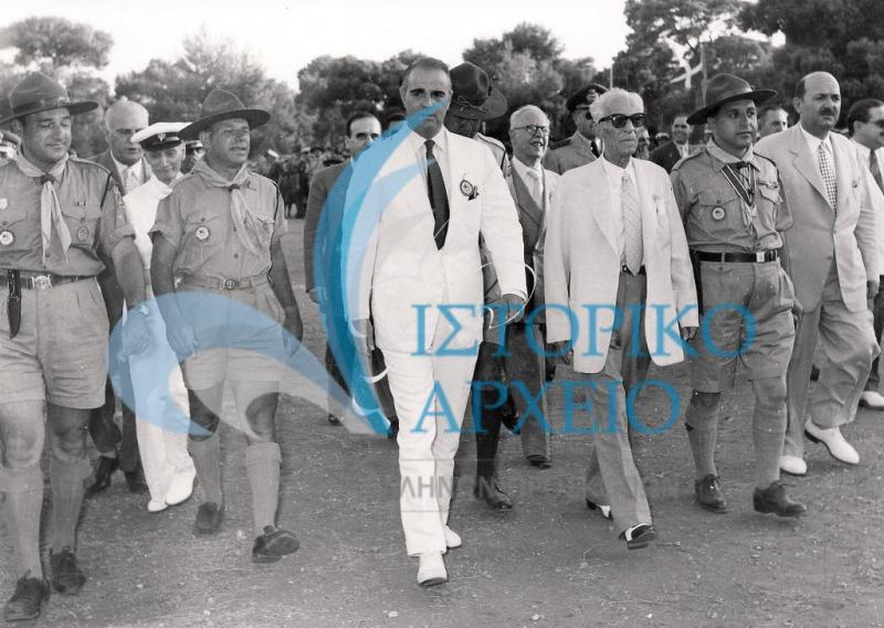 Ο Πρωθυπουργός Κωνσταντίνος Καραμανλής με τον Υπουργό Εθνικής Παιδείας & Θρησκευμάτων Πέτρο Λεβάντη  προσέρχονται στην Πυρά Έναρξης του Τζάμπορη Αποδήμων το 1956. Συνοδεύονται από τους: Δ. Αλεξάτο, Δ. Μακρίδη, Μ. Σοφιανό και Σκυριανίδη.
