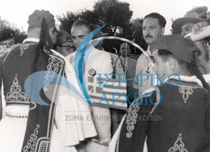 Ο Πρωθυπουργός Κωνσταντίνος Καραμανλής δένει τον τελευταίο κρίκο στην αλυσίδα με την πόλης των αποδήμων Ελλήνων προσκόπων κατά την Πυρά Έναρξης του Τζάμπορη Αγίου Ανδρέα το 1956.