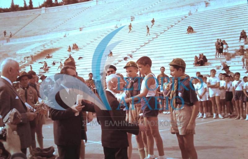 Ο Πρόεδρος Μ. Σοφιανός απονέμει έπαθλα σε λυκόπουλα στο Στάδιο κατά τους Δ` Αθλητικούς Αγώνες της ΠΕ Πρωτευούσης το 1958.