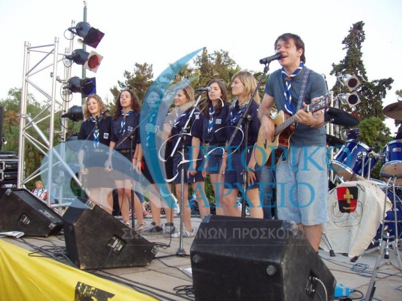 Ναυτοπρόσκοποι τραγουδούν με τον Ευτύχη Μπλέτσα στο τέλος της δράσης "Ανθρώπινο Ντόμινο" το 2004.