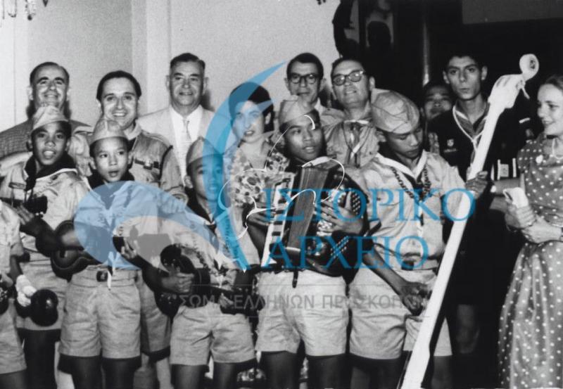 Ο Δ. Μακρίδης μαζί με μέλη της ελληνικής αποστολής τραγουδούν με Φιλιππινέζους προσκόπου στο Τζάμπορη του 1959. 
