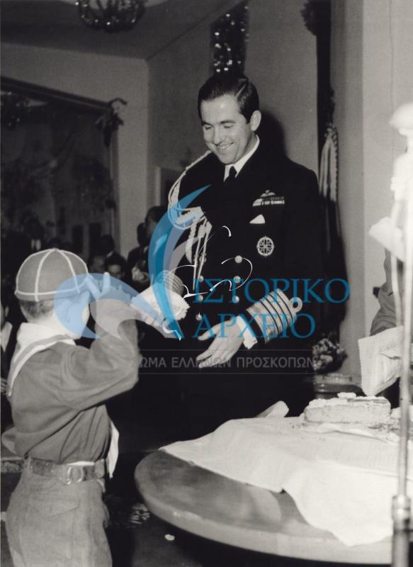 Ο Βασιλιάς Κωνσταντίνος δίνει κομμάτι από την Πρωτοχρονιάτικη Βασιλόπιτα του 1966 σε λυκόπουλο.