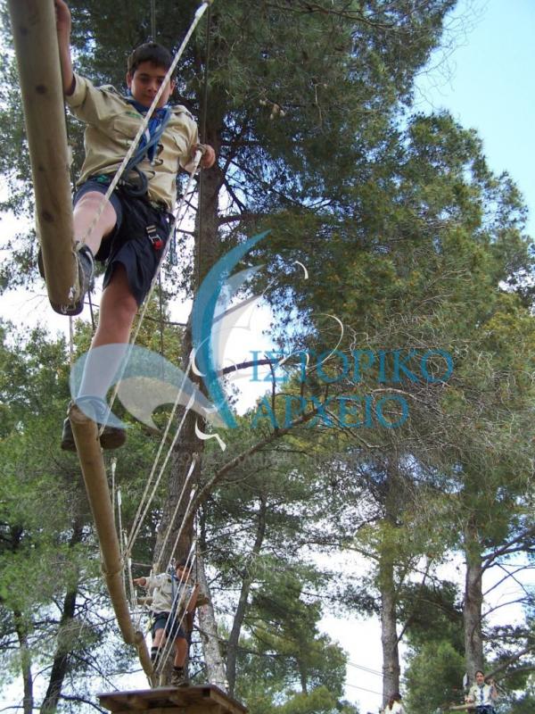 Πρόσκοπος περνά από αυτοσχέδια γέφυρα.