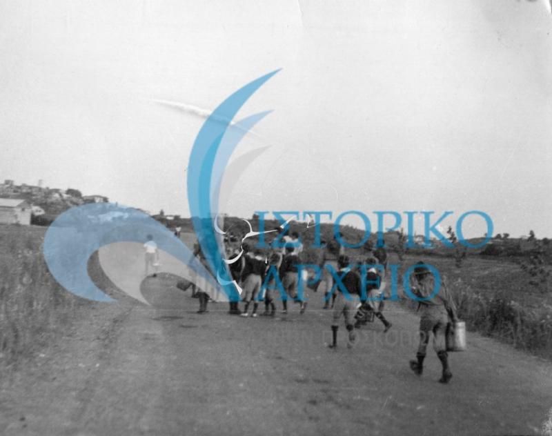 Πρόσκοποι της Κατοχής Αιτ/νίας ποτίζουν νεά δεντρύλλια δίπλα σε δρόμο το 1977.