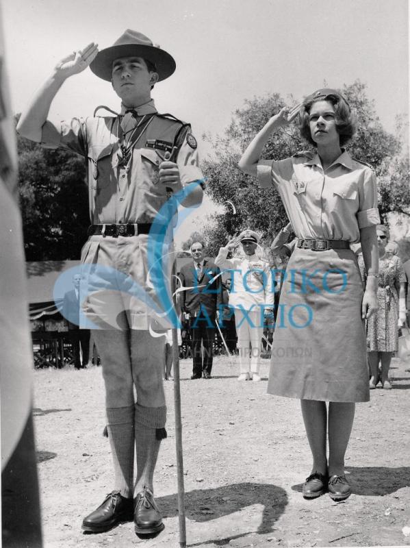 Ο Βασιλιάς Κωνσταντίνος με στολή προσκόπου και η Πριγκίπισσα Ειρήνη με στολή Οδηγού κατά την μετονομασία του Προσκοπικού Κέντρου Πύργου Βασιλίσσης σε "Λόφο Σχολών" το 1964.