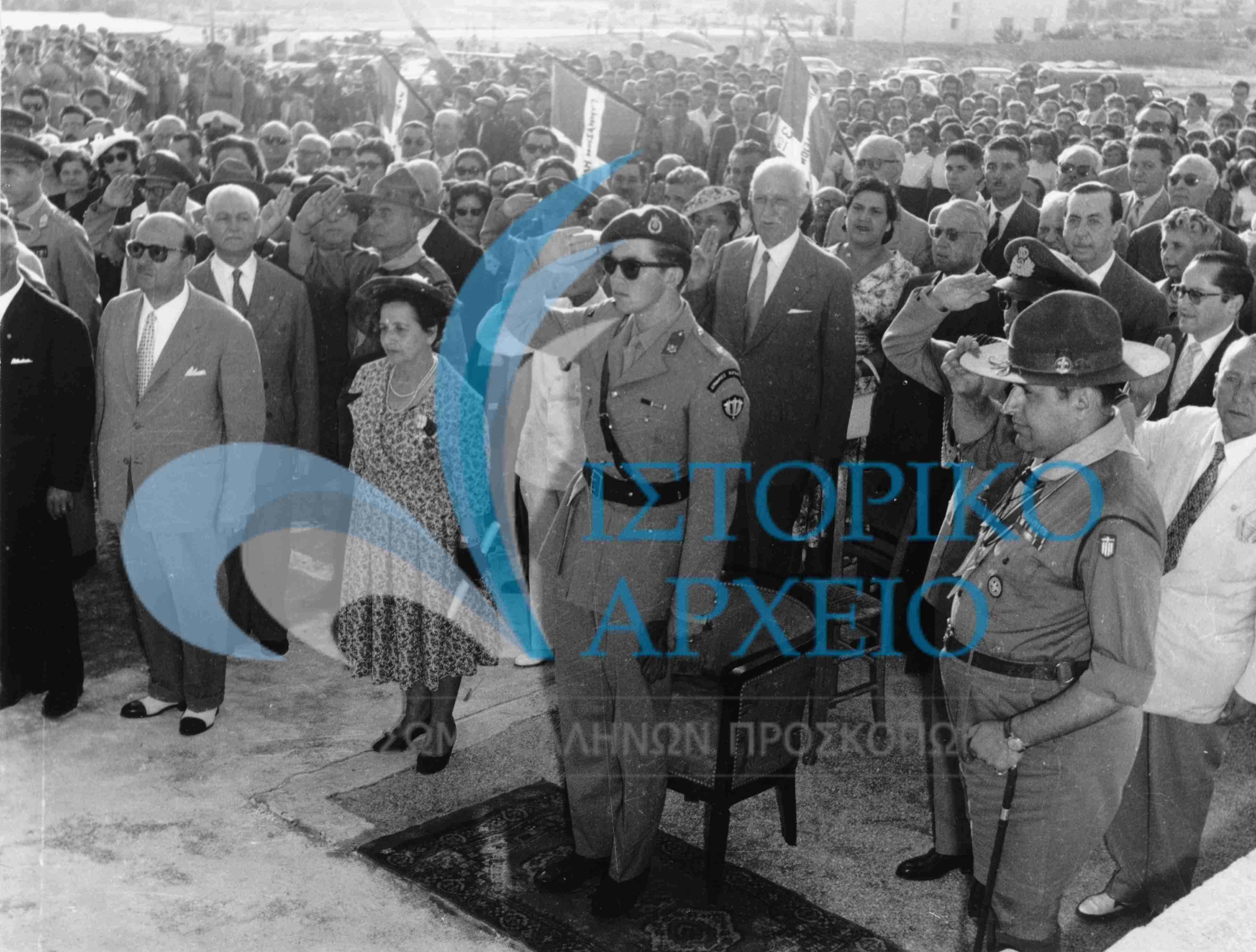 Ο Διάδοχος Κωνσταντίνος στον αγιασμό εγκαινίων προσκοπικής εστίας στην Άνω Ηλιούπολη τον Μάιο του 1959. Στα δεξιά διακρίνεται ο ΓΕ Δ. Αλεξάτος μαζί με μέλη της τοπικής ΕΚΣ.