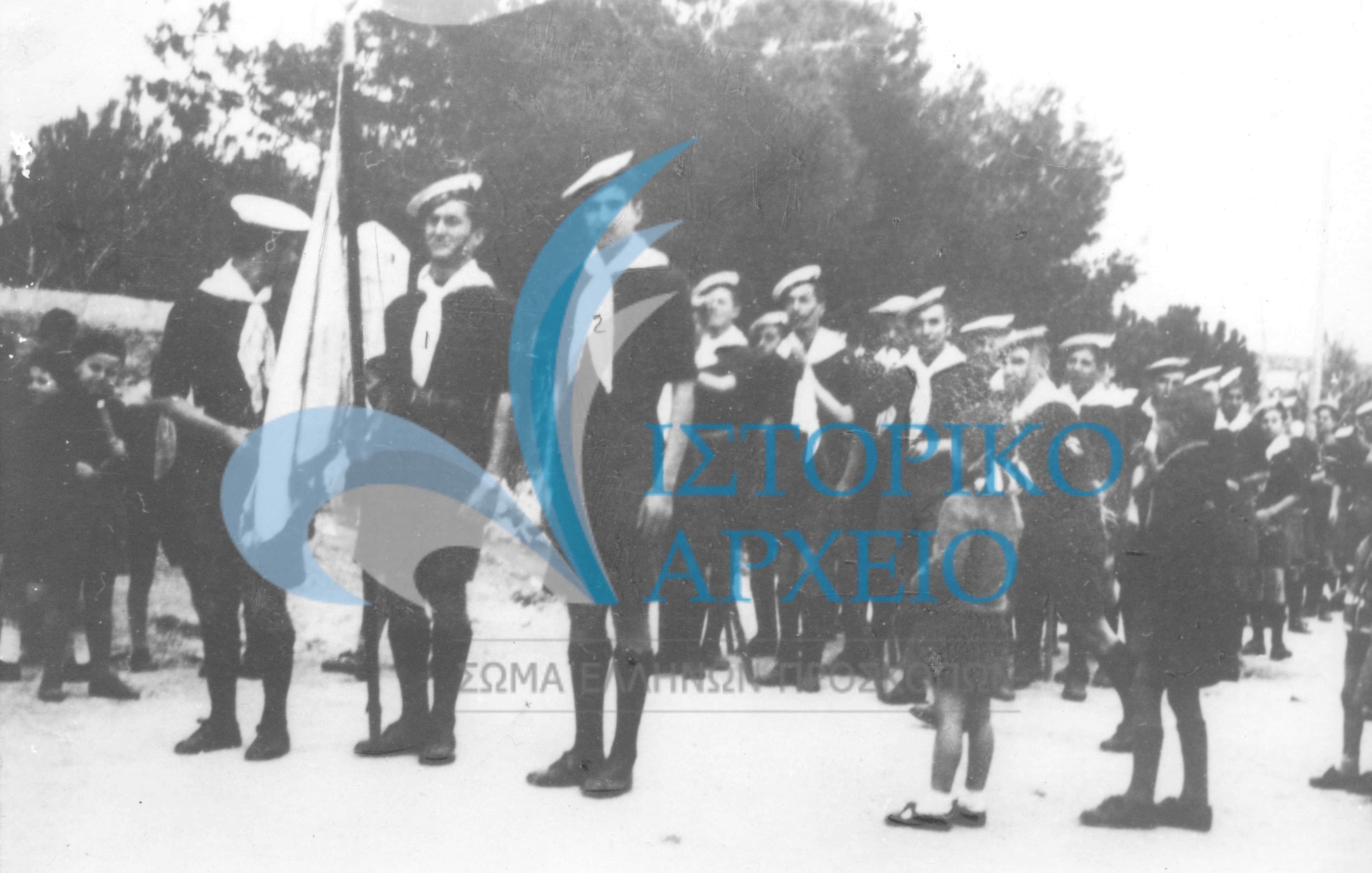 Από την τελετή παράδοσης της Σημαίας της Προσκοπικής Ομάδας Ρεθύμνου στην Εθνική Οργάνωση Νεολαίας το 1939. Σημαιοφόρος ο Γεώργιος Τρέτζος και παραστάτης ο Στ. Παναγιωτάκης.