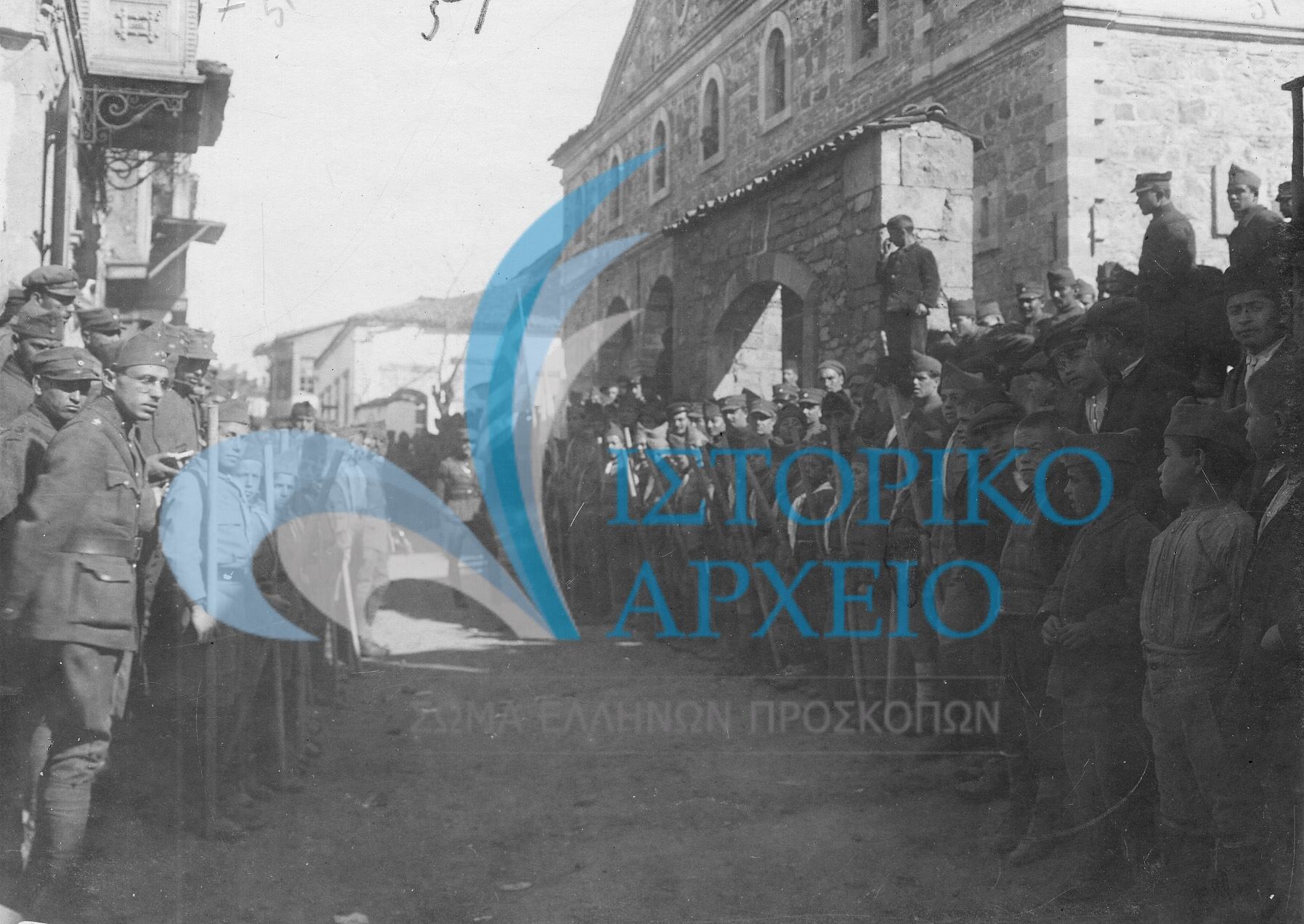 Παρατεταγμένοι πρόσκοποι, οπλίτες και αξιωματικοί του Ελληνικού Στρατού μπροστά από κτίριο ελληνική διοίκησης κατά την άφιξη επισήμου σε δράση της Β' Μεραρχίας Σμύρνης.