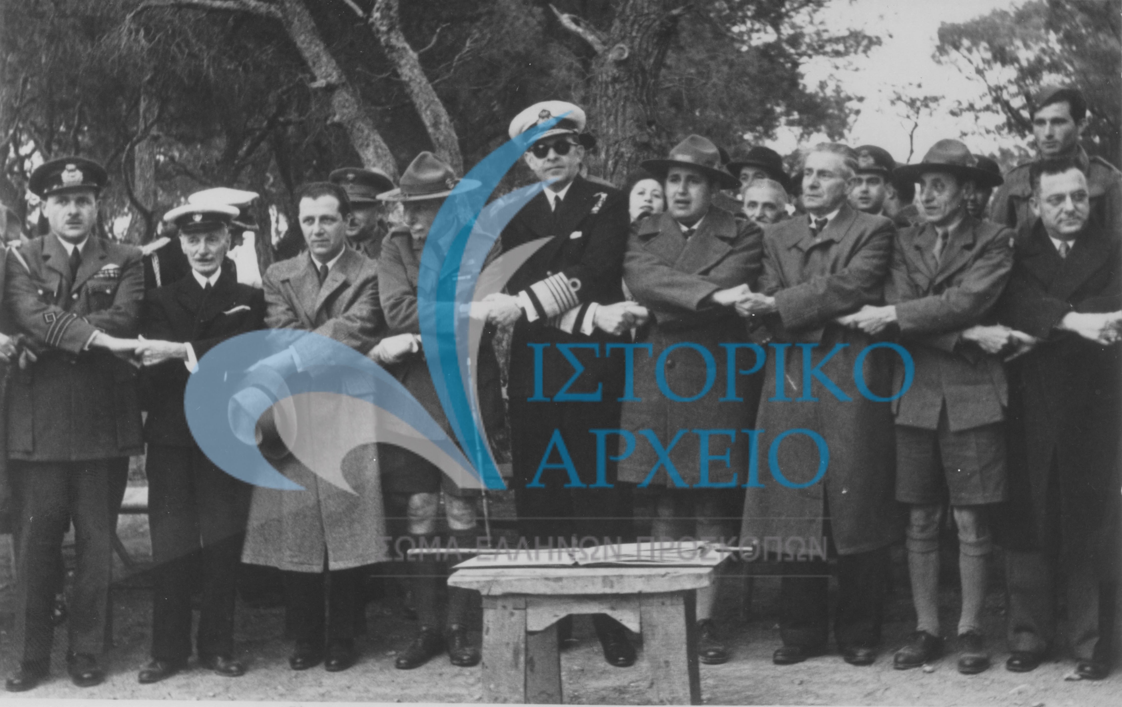 Από την 1η Συνάντηση Πτυχιούχων Διακριτικού Δάσους τον Μάιου του 1949 στο ΠΥΒΑ. Στη μέση διακρίνεται ο Βασιλιάς Παύλος και στο πλάι του ο Αρχιπρόσκοπος Αντ. Μπενάκης και ο ΓΕ Δ. Αλεξάτος. Επίσης ο πρώτος ΓΕ Λ. Πτέρης και ο ΓΓ Μ. Σοφιανός και ο καθηγητής και μέλος ΔΣ Α. Τσιριντάκης.