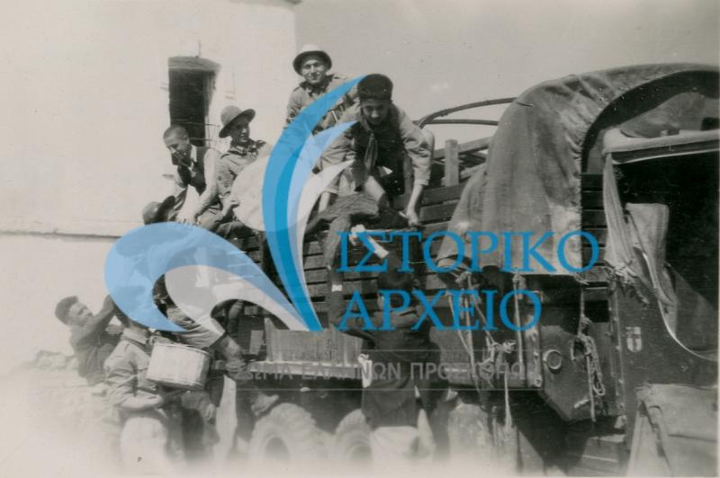 Πρόσκοποι από την Βέροια ξεφορτώνουν βοήθεια σε κατοίκους που επανήλθαν στην Συκιά Ημαθίας στο τέλος του Εμφυλίου το 1950.   