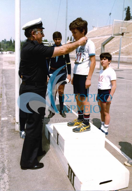 Ο ΠΕ Σαρωνικού Γ. Κατσαμπής απονέμει έπαθλα σε αγώνες Λυκοπούλων του Σαρωνικού στο Στάδιο το 1981.