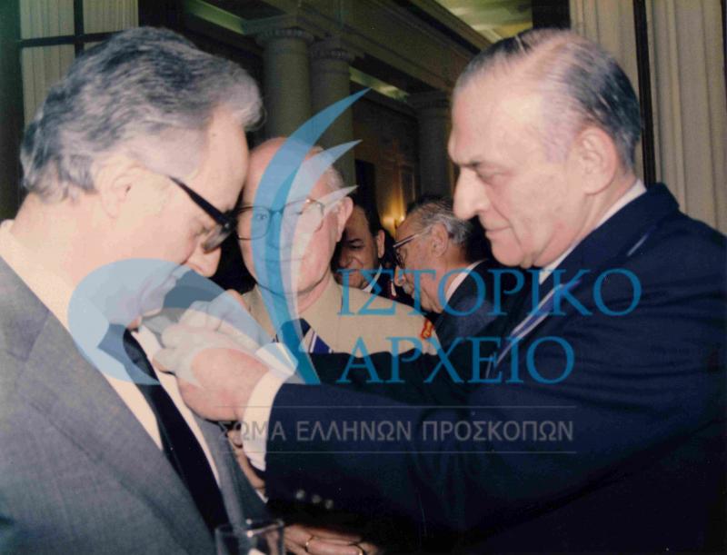 Ο Πρόεδρος του ΔΣ Στέλιος Ναουμίδης απονέμει μετάλλιο στον Πρόεδρο της Δημοκρατίας, Χρήστο Σαρτζετάκη σε εκδήλωση το 1987. Διακρίνεται ο Αν. Σάγος.